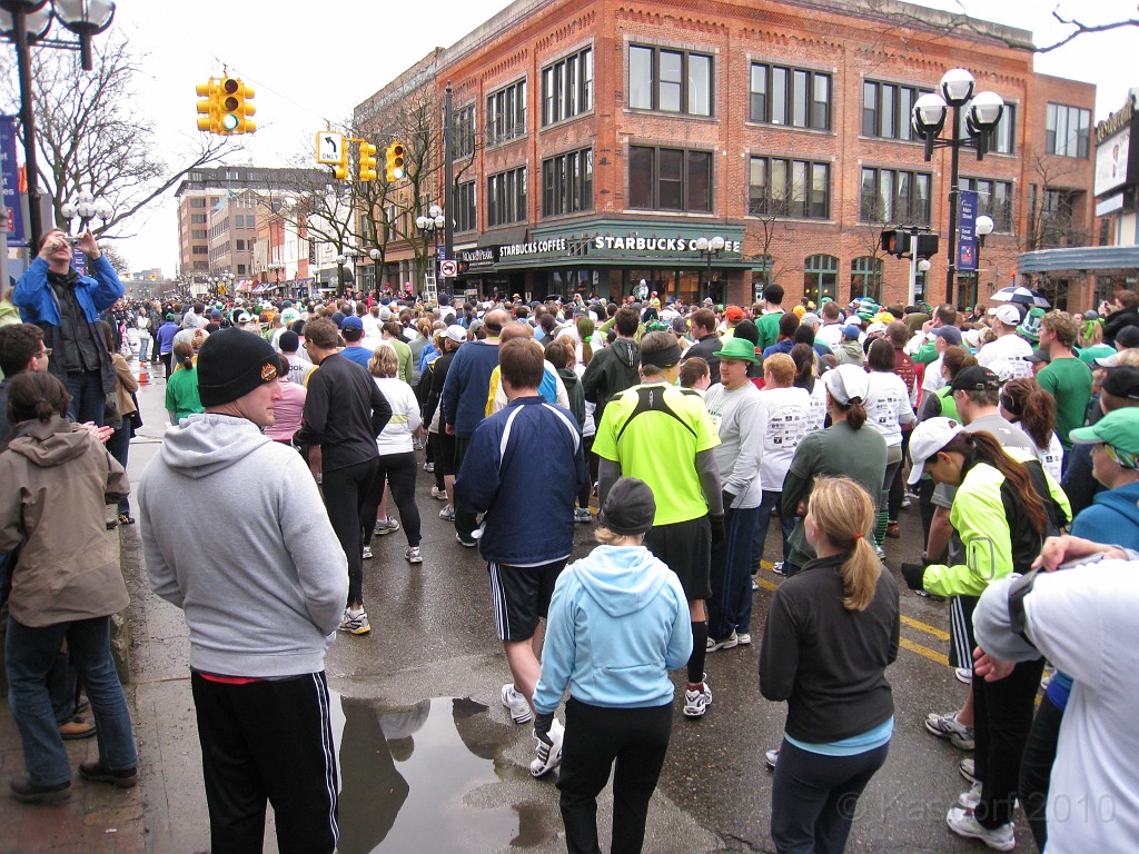 Shamrocks and Shenanigans 5K 2010 0360.jpg - The 2010 Shamrocks and Shenanigans 5K race in Ann Arbor MI. Cool and damp, and crowded. Squeezing a two lane street into one lane to go across the timing mat, and at the same time the walkers are merging from the right side street!!
